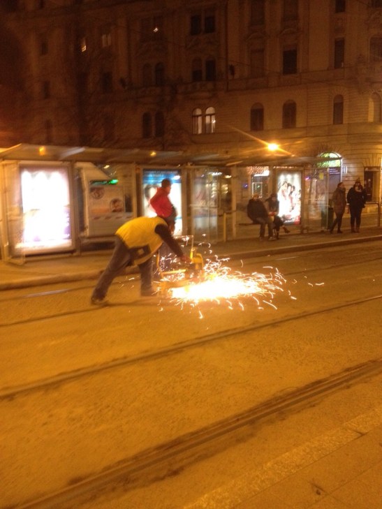 Tram maintenance near a bus stop in Budapest.